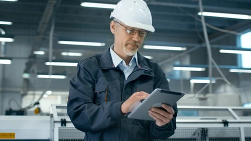 ingeniero en fabrica mirando a una tablet